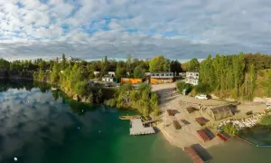 Piękna, piaszczysta plaża nad turkusową wodą, z pomostami i budynkami. Idealne miejsce na wypoczynek.