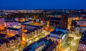 Nocny widok na miasto nad Kaczawą, z oświetloną katedrą i ulicami.