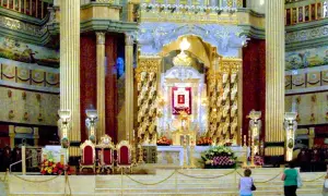 Wnętrze bazyliki w Licheniu Starym. Złote zdobienia, ołtarz główny i wierni przygotowujący się na nadchodzące wydarzenia.