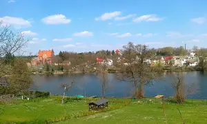 Malowniczy widok na jezioro z zamkiem i zabudowaniami w tle. Biały Bór Podkarpackie zachwyca spokojem i pięknem natury.