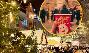 Ciepły kubek z reniferem na jarmarku bożonarodzeniowym w Pradze. Tłumy ludzi, choinki i świąteczne iluminacje tworzą magiczną atmosferę.