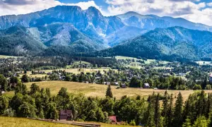 Widok na Zakopane z górami w tle. Warto sprawdzić ceny noclegów i atrakcji, by zaplanować udany pobyt.