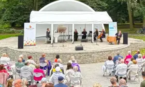 Koncert kameralny na scenie plenerowej w Kędzierzynie-Koźlu. Publiczność w różnym wieku zgromadzona na widowni.