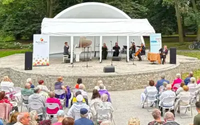 Koncert kameralny na scenie plenerowej w Kędzierzynie-Koźlu. Publiczność w różnym wieku zgromadzona na widowni.