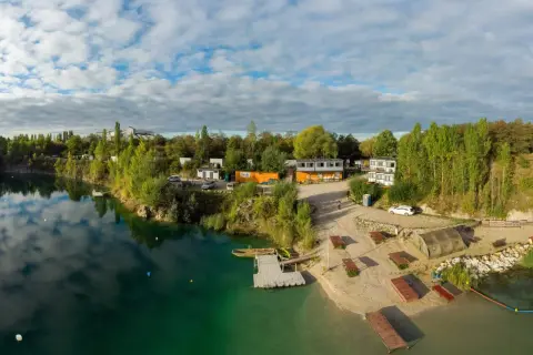 Piękna, piaszczysta plaża nad turkusową wodą, z pomostami i budynkami. Idealne miejsce na wypoczynek.