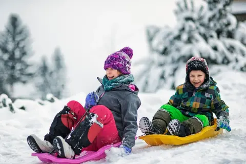 Dzieci szaleją na sankach podczas ferii zachodniopomorskich. Radość i śnieg tworzą idealne wspomnienia.