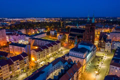 Nocny widok na miasto nad Kaczawą, z oświetloną katedrą i ulicami.