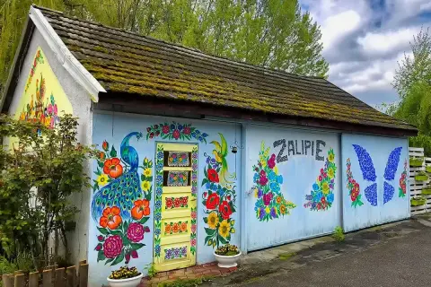Kolorowy paw i kwiaty zdobią budynek w Zalipiu. Wspaniałe miejsce na zwiedzanie, pełne ludowej sztuki.