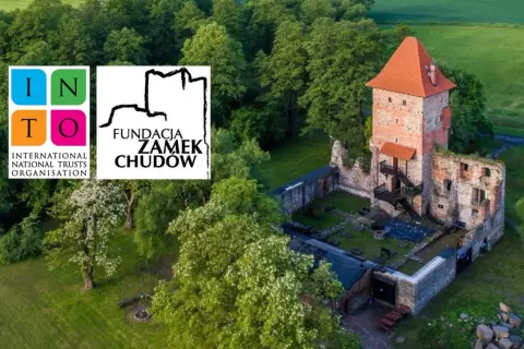 Zamek Chudów, ruiny i wieża z czerwonym dachem, otoczone zielenią. Logo Fundacji Zamek Chudów i INTO.