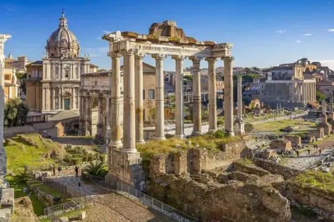 Starożytne ruiny Forum Romanum w Rzymie, z kopułą kościoła w tle. Wyobraź sobie, że stąd wyruszasz do Wenecji, pokonując tę odległość.