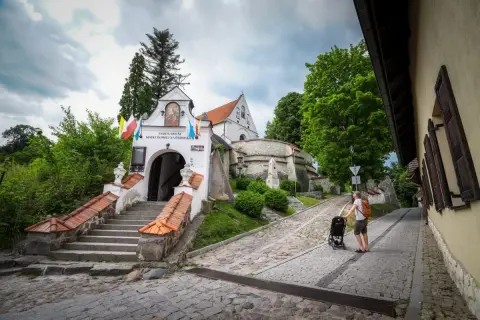 Droga do Sanktuarium Matki Bożej w Trzcińcu Lubelskim. Mężczyzna z wózkiem idzie brukowaną uliczką.