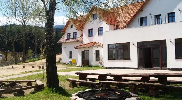 Wypoczynek w **jagniątkowie** to relaks przy ognisku i drewnianych ławach. Białe budynki z czerwonymi dachami otoczone zielenią.