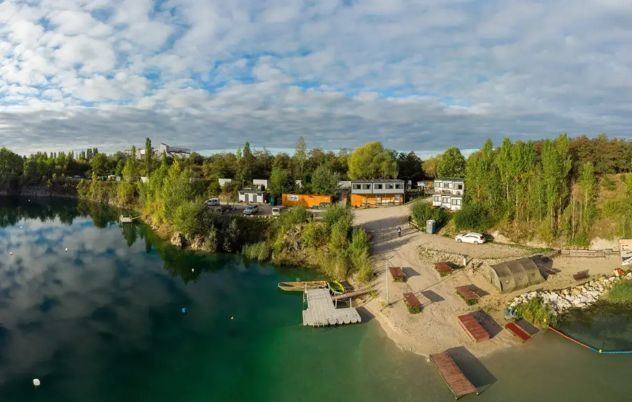 Piękna, piaszczysta plaża nad turkusową wodą, z pomostami i budynkami. Idealne miejsce na wypoczynek.