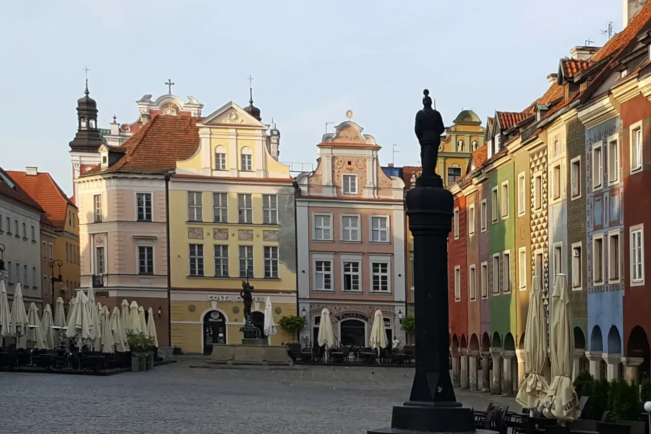 Na Rynku w Poznaniu stoi pręgierz, co to za budowla? Kolorowe kamienice i zamknięte kawiarnie tworzą tło dla tego historycznego miejsca.