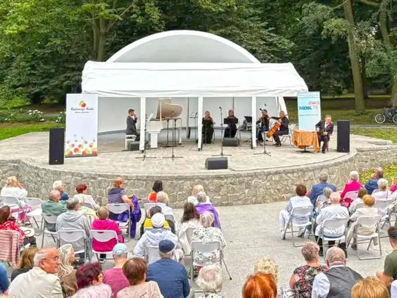Koncert kameralny na scenie plenerowej w Kędzierzynie-Koźlu. Publiczność w różnym wieku zgromadzona na widowni.