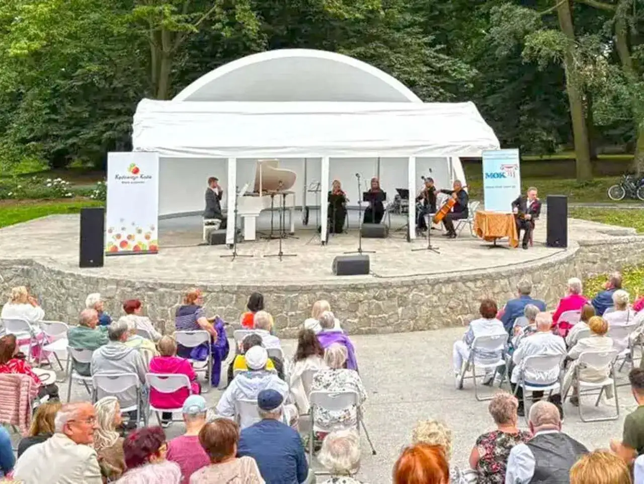 Koncert kameralny na scenie plenerowej w Kędzierzynie-Koźlu. Publiczność w różnym wieku zgromadzona na widowni.