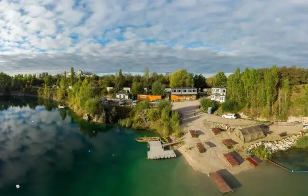 Piękna, piaszczysta plaża nad turkusową wodą, z pomostami i budynkami. Idealne miejsce na wypoczynek.