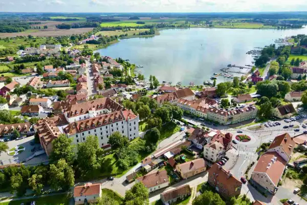 Widok na miasteczko nad jeziorem, gdzie znane miejscowości wypoczynkowe na Mazurach to właśnie takie urokliwe zakątki z mariną i zabytkową architekturą.